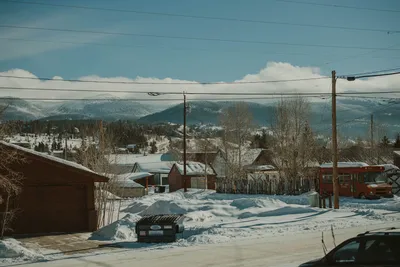 Snow-covered rural village in Colorado with mountains and rustic buildings.