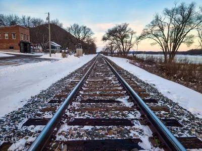 Winter scene of railroad tracks through Reads Landing, Minnesota at sunset.